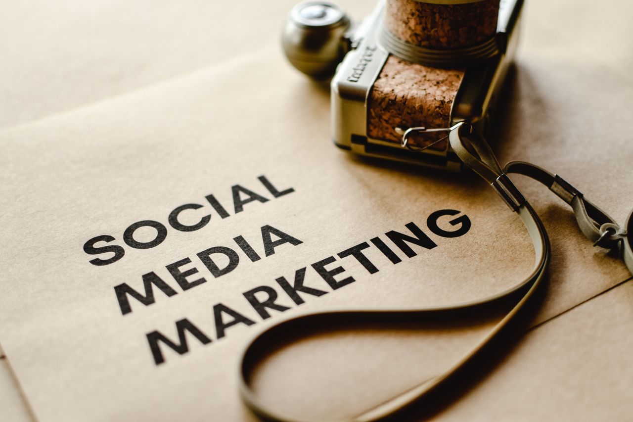 Close-up of a camera placed on brown paper with Social Media Marketing text, emphasizing digital marketing themes.