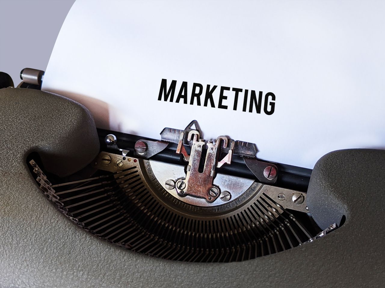 Close-up of a vintage typewriter with the word Marketing on paper, conveying a retro business theme.